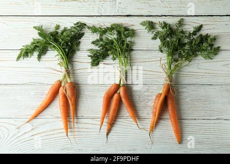 Frische Karotten mit Seil auf weißem Holztisch gebunden Stockfoto