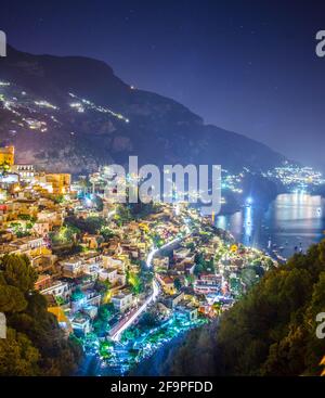 Nachtansicht der beleuchteten stadt positano in italien. Stockfoto