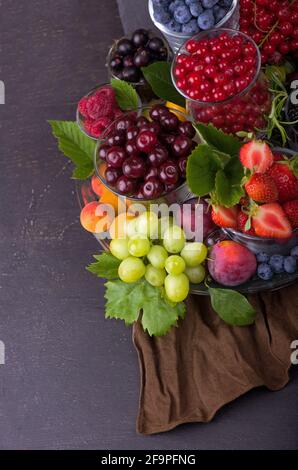 Verschiedene Sommerbeeren rote Johannisbeere, Stachelbeere, Himbeere in Glasschalen. Sortiert nach Art. Stockfoto