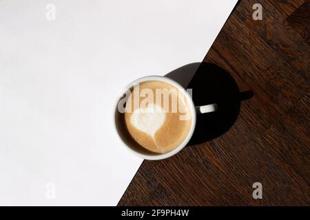 Overhead of Cappuccino with Heart Latte Art. Hausgemachter Kaffee mit cremigem Milchschaum. Stockfoto