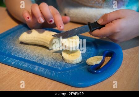 12.02.2020, Berlin, Berlin, Deutschland - Kinderhände schneiden Obst. 0CE200212D003CAROEX.JPG [MODEL RELEASE: NO, PROPERTY RELEASE: NO (c) caro images Stockfoto