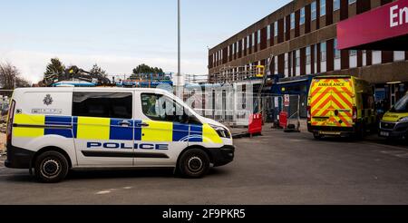 Ein Polizeiwagen parkte zwischen den Krankenwagen im Diana Princess of Wales Hospital, Grimsby, und zeigte unsere gestreckten Frontservices in der Pandemie Stockfoto