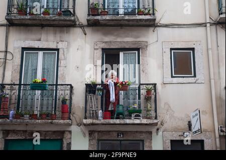 12.06.2018, Lissabon, , Portugal - eine alte Frau steht auf dem Balkon ihrer Wohnung in der Altstadt der portugiesischen Hauptstadt. 0SL180612D019CAROEX.JP Stockfoto