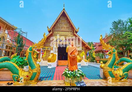 Die Ubosot (Ordinationshalle) von Wat Phra Singh mit verzierten Skulpturen von Naga-Schlangen und einem Bild des Bhikkhu-Mönchs mit Spendenschale, Chiang Rai, Stockfoto