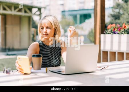 Erwachsene Frau in Brille mit Laptop Stockfoto