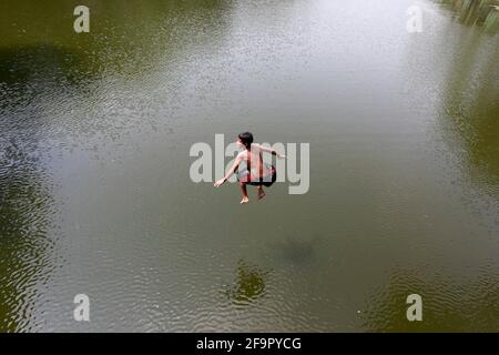 Dhaka, Bangladesch - 20. April 2021: Es ist Sommer in Bangladesch. Unfug im Wasser des Dhanmondi Lake in Dhaka für eine kleine Erleichterung für die Straße Chi Stockfoto