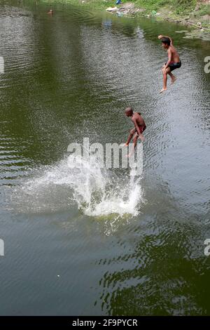 Dhaka, Bangladesch - 20. April 2021: Es ist Sommer in Bangladesch. Unfug im Wasser des Dhanmondi Lake in Dhaka für eine kleine Erleichterung für die Straße Chi Stockfoto