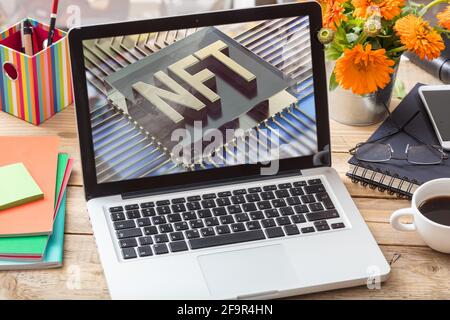 NFT nicht fungible Token blauer Text auf Laptop-Bildschirm des Computers, Büroschreibtischhintergrund. Kryptographisches Token, Blockchain-Asset, Krypto-Art-Konzept Stockfoto