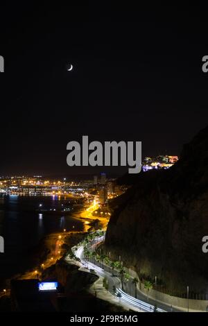 Blick auf die Küste der Stadt alicante bei Nacht mit der bunten Beleuchtung der Burg von Santa Barbara, Valencia, Spanien. Landschaft Stockfoto