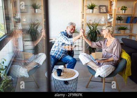 Schöne alte Paar ist ein Buch zu lesen und zu Hause lächeln Stockfoto