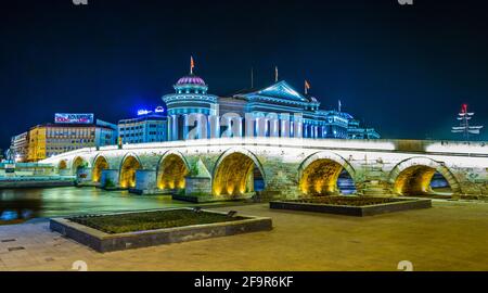 Nachtansicht der Steinbrücke und des archäologischen Museums in der mazedonischen Hauptstadt skopje. Stockfoto