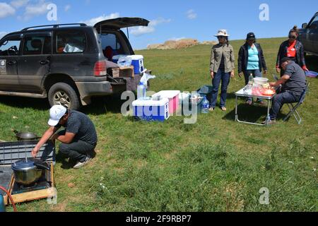 Eine Reisegruppe hält zum Mittagessen in der Steppe nahe der Straße zwischen Karakorum und Ulaanbaatar, Mongolei. Stockfoto