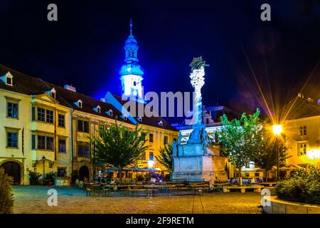 Nachtansicht des beleuchteten Fo ter - Hauptplatzes In der ungarischen Stadt Sopron einschließlich der heiligen dreifaltigkeitskolonne und Der berühmte Feuerturm Stockfoto