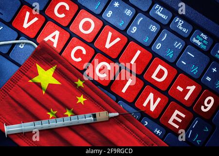 COVID-19-Impfung in China mit Spritze und Gesichtsmaske mit chinesischer Flagge und Impfhinweis auf der Computertastatur. Konzept der Covid-Impfung Stockfoto