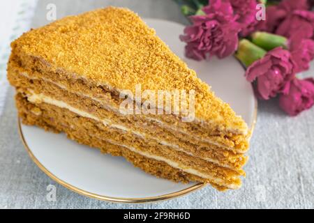 Köstlicher Kuchen und Blumen auf dem Tisch Stockfoto