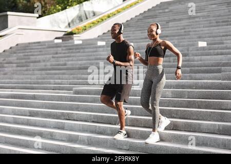 Active Black Athlete Couple Läuft Im Freien Auf Stufen In Urban Parken Stockfoto