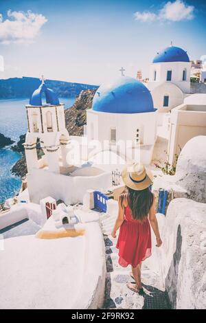 Reiseziel europa Tourist Girl zu Fuß in Santorini an den drei blauen Kuppeln, berühmte griechische Wahrzeichen. Oia Village, Santorini Insel, Luxus Stockfoto