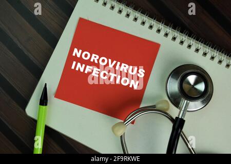 Norovirus-Infektion Schreiben Sie auf Haftnotizen isoliert auf Holztisch. Stockfoto