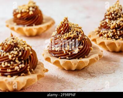 Hausgemachte Desserts mit Karamell, Nüsse auf hellem Hintergrund Stockfoto