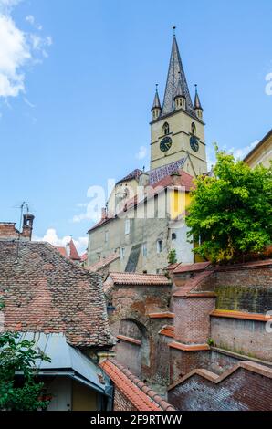 Blick auf das Dach eines typischen Hauses in rumänischen sibiu Über dem Sie den Turm der lutherischen Kathedrale sehen können Der heiligen maria Stockfoto