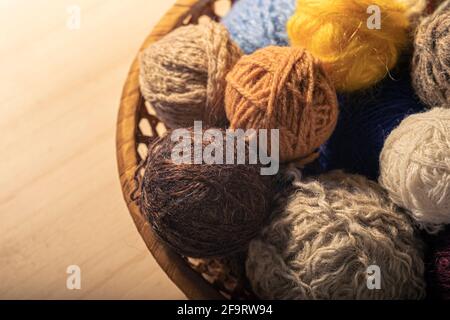 Knitting supplies close-up. Balls of knitting wool in a round wicker basket. Stockfoto