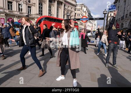 Passanten treffen sich am 11. April 2021 im Piccadilly Circus in London, Großbritannien, mit einem Gruppentanz. Nach monatelanger Sperre waren die Teilnehmer voller Freude und Zweisamkeit, um in der Stadt zu sein und Spaß mit so vielen anderen Menschen zu haben. Stockfoto