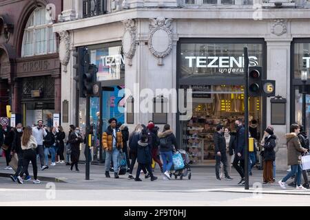 Die Käufer kehren in die Oxford Street zurück, da die nicht unbedingt notwendigen Geschäfte wieder geöffnet werden und das nationale Coronavirus am 12. April 2021 in London, Großbritannien, die Sperre von Three fällt. Jetzt, da die Roadmap für das Auslaufen der nationalen Sperre festgelegt wurde, ist dies die erste Phase der Lockerung der Beschränkungen, und eine große Anzahl von Menschen ist in Londons Einzelhandelsviertel mit Einkaufstaschen beladen. Stockfoto