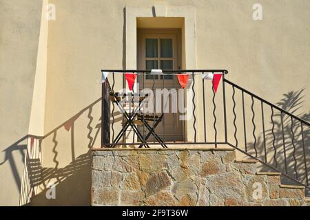 Typische Fassade eines Hauses im Provençal-Stil mit ockerfarbener Stuckwand und handgefertigtem Treppengeländer aus Eisen in Saint-Tropez an der französischen Riviera. Stockfoto