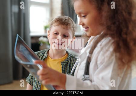 Zwei Freunde, die zu Hause gemeinsam mit dem Röntgenbild spielen Stockfoto