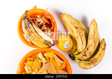 Mit verdorbenen Früchten und anderen organischen Küchenabfällen in Schüsseln, auf weißem Hintergrund. Stockfoto