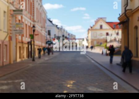 Verschwommenes Bild mit Menschen, die in Grodno Weißrussland auf einer Wall Street im europäischen Baustil spazieren. Als Hintergrund und Hintergrund sowie als Reiseszene Stockfoto