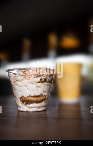 Dessert in einer Plastikbecher vor dem Hintergrund von Kaffee in einem Café. Stockfoto