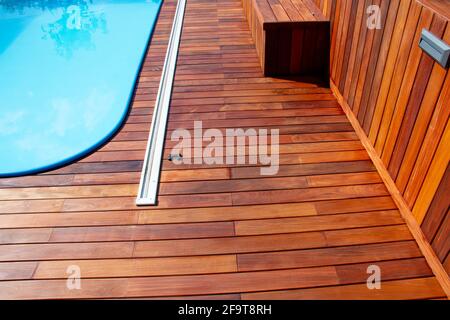 Braune Ipe Holzterrasse und blauer Swimmingpool Stockfoto