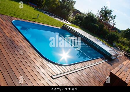 IPE Holzterrasse um den Pool mit Blick aus einem hohen Winkel, wunderschöne Ipe-Holzterrasse um den Pool herum, die IPE-Terrasse umrandt Stockfoto