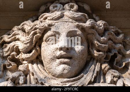 In Stein gemeißeltes Frauengesicht, wahrscheinlich eine Allegorie des Glücks, Fassadenschmuck eines alten Gebäudes in Paris, Frankreich Stockfoto