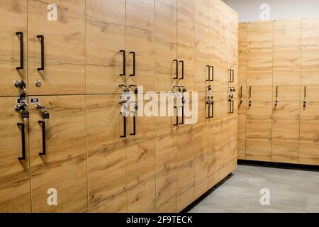 Holzschrankboxen mit Metallschlössern. Klassische Holz Umkleideraum und eine Bank. Stockfoto