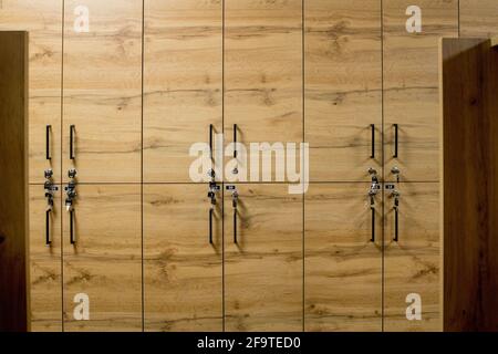 Holzschrankboxen mit Metallschlössern. Klassische Holz Umkleideraum und eine Bank. Stockfoto