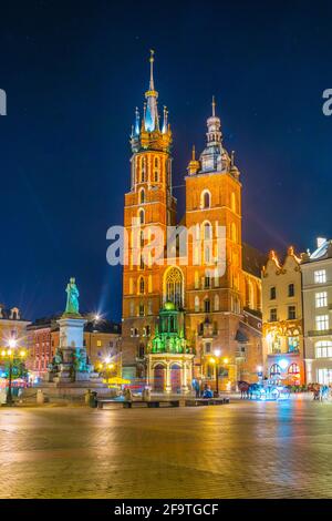 Nachtansicht der Marienkirche mit der Statue von adam mickiewicz auf dem rynek glowny Hauptplatz in der polnischen Stadt Krakau. Stockfoto