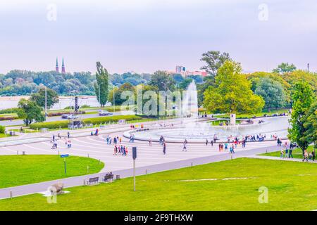 Um den Multimedia Fountain Park versammeln sich Menschen, um die beleuchteten Brunnen in Warschau, Polen, zu sehen. Stockfoto