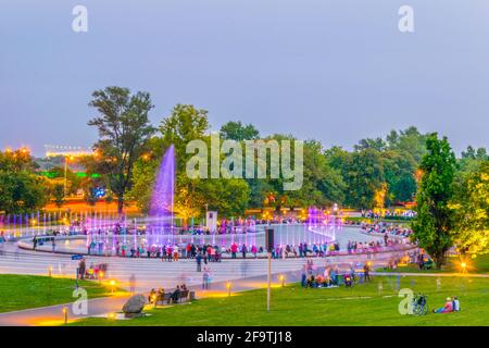 Um den Multimedia Fountain Park versammeln sich Menschen, um die beleuchteten Brunnen in Warschau, Polen, zu sehen. Stockfoto