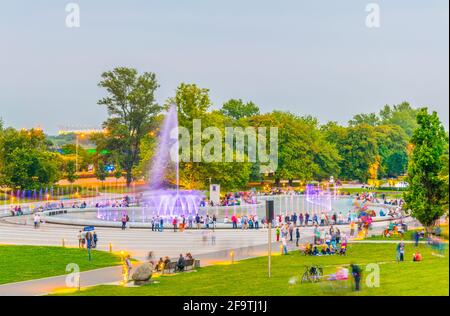 Um den Multimedia Fountain Park versammeln sich Menschen, um die beleuchteten Brunnen in Warschau, Polen, zu sehen. Stockfoto