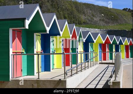 Barry Island, Wales, Großbritannien - 17. April 2021: Eine Reihe farbenfroher Strandhütten auf Barry Island. Barry ist eine lebendige Küstenstadt mit einer belebten High Street Stockfoto