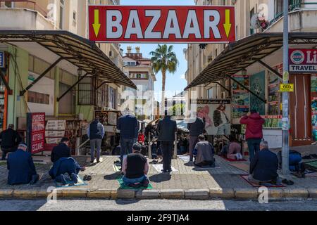 Menschen, die während der Tage der Coronavirus-Pandemie am 3. April 2021 auf der Straße des Basars von Alanya beten. Stockfoto