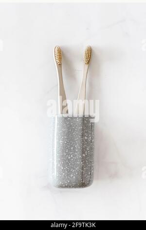 Komposition mit biologisch abbaubaren Bambus-Zahnbürsten auf Marmorboden. Nachhaltig, Null Abfall, plastikfrei, Lifestyle-Konzept. Umweltfreundliches Mundhygiene-Zubehör. Flach liegend, Draufsicht. Stockfoto