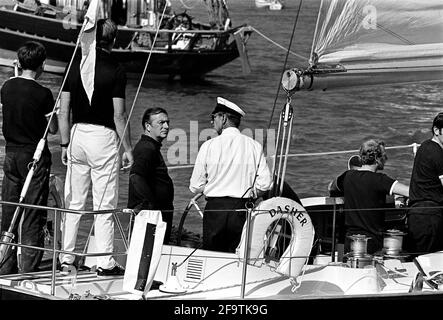 AJAXNETPHOTO. AUGUST 1975. COWES, ENGLAND, - DUKE SIEHT DIE ACTION - PRINZ PHILIP, DER HERZOG VON EDINBURGH, AN DER SPITZE DER YACHT DASHER. FOTO;JONATHAN EASTLAND/AJAX REF:750003003 Stockfoto