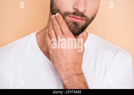 Abgeschnitten Nahaufnahme Porträt von schönen attraktiven Kerl berühren unrasiert Kinn isoliert auf beigefarbenem pastellfarbenem Hintergrund Stockfoto