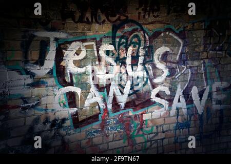 Religiöse Graffitti an der Wand des redundanten Küstenluftangriffs-Sheltergraffiti Stockfoto