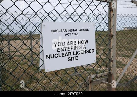 Warnschild an einem Drahtzaun mit der Meldung „Sie betreten jetzt einen nuklearen Standort“ gemäß dem Nuclear Installations Act 1965, Dungeness, Kent, Großbritannien Stockfoto