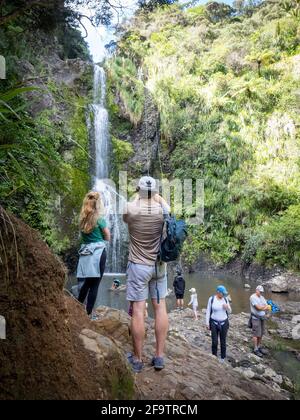 AUCKLA, NEUSEELAND - 18. Apr 2021: Blick auf Touristen auf die Kitekite Falls, Piha, Auckland Stockfoto