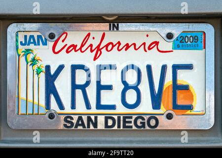 California Vanity Plate bedeutet KREATIVES, personalisiertes Kennzeichen für besondere Interessen mit stilisierten Palmen und Sonnenuntergang und San Diego Plate Frame Stockfoto